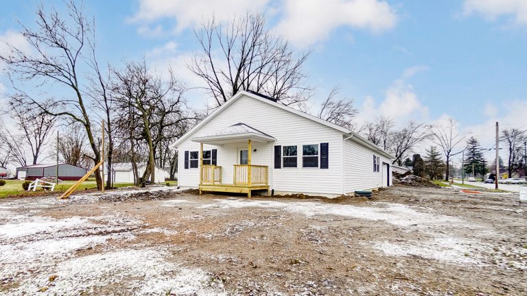 One-story home with white siding and wooden covered porch.